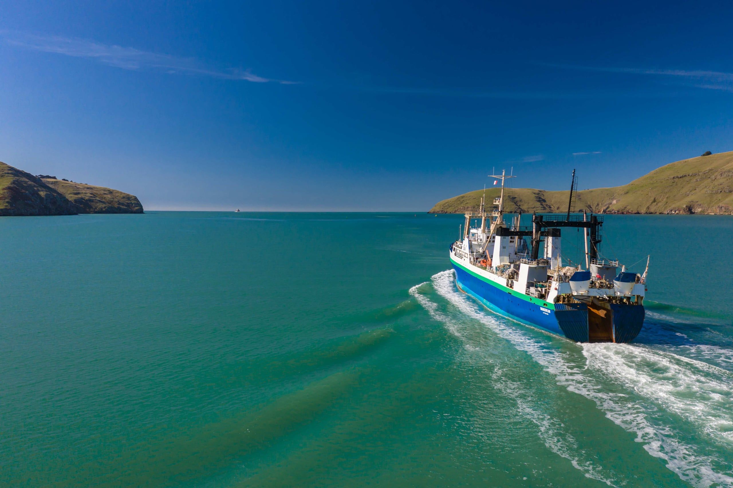 A vessel approaching shore in shallow turquoise water